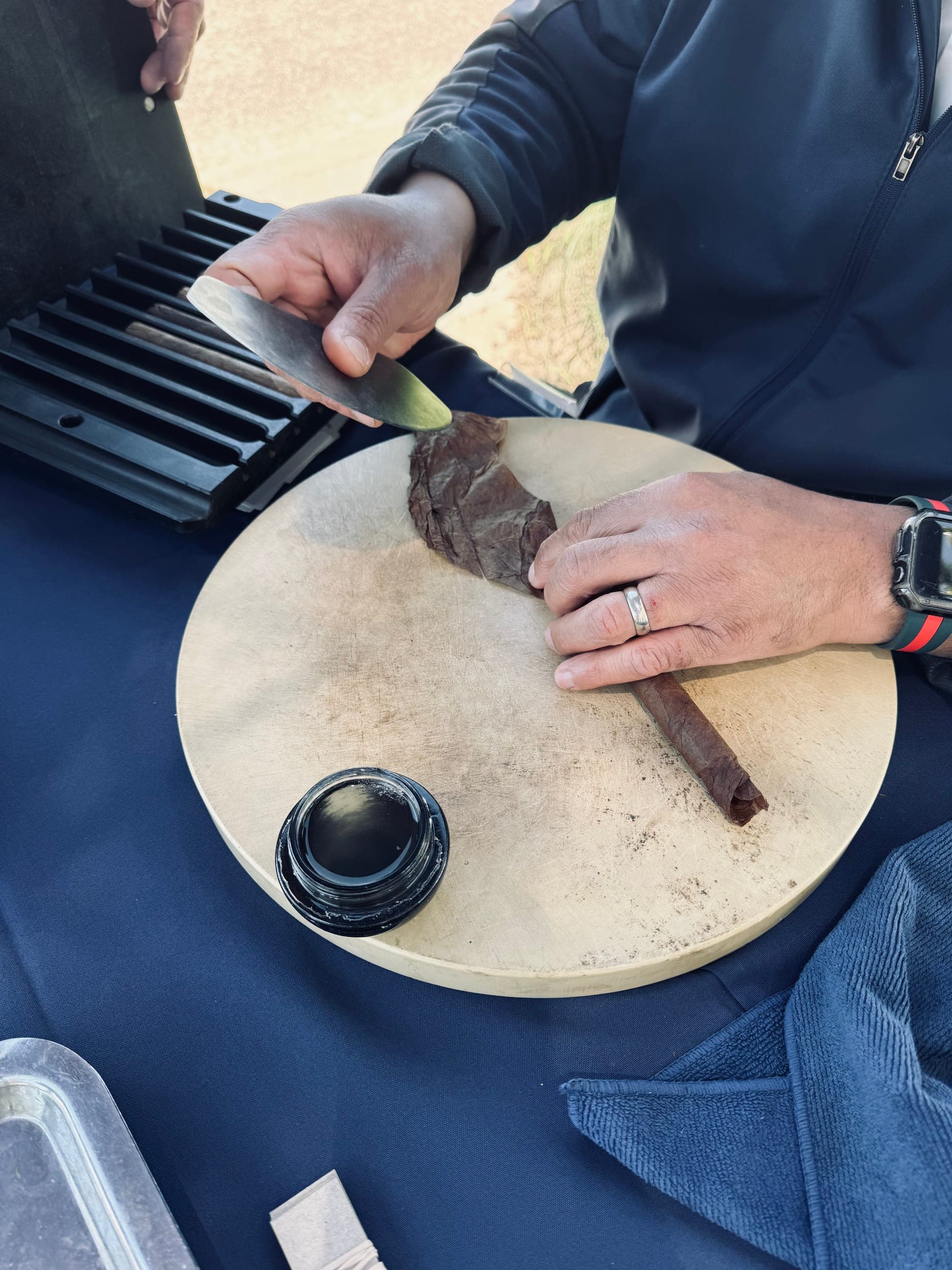 Close-up of a cigar being rolled with tobacco leaf and rolling glue
